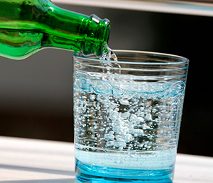 Газированная вода льётся из бутылки в стакан